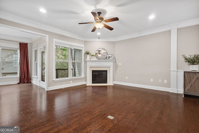 unfurnished living room with a glass covered fireplace, crown molding, baseboards, and wood finished floors