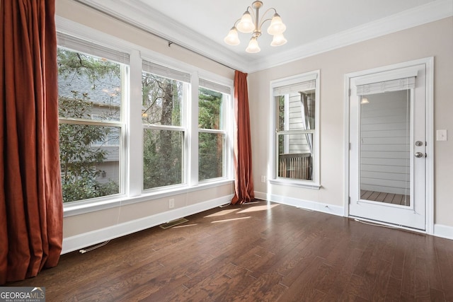 interior space with a notable chandelier, baseboards, wood finished floors, and crown molding