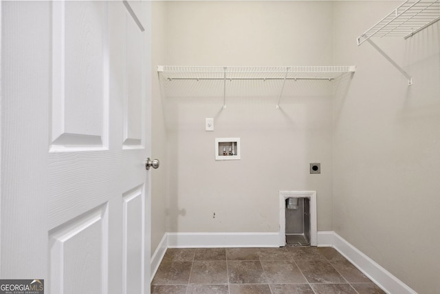 clothes washing area with hookup for a washing machine, stone finish floor, electric dryer hookup, laundry area, and baseboards