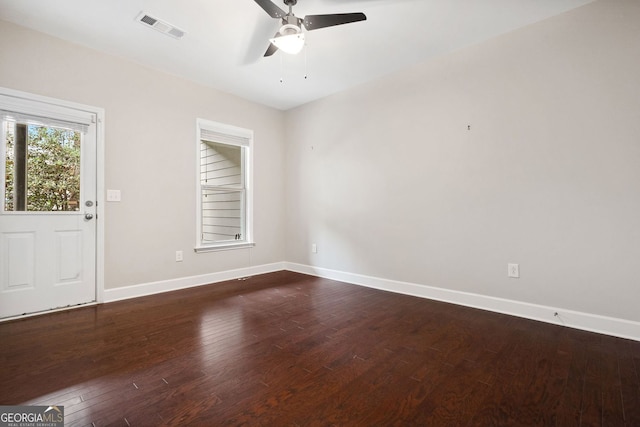 empty room with dark wood-style floors, baseboards, visible vents, and ceiling fan