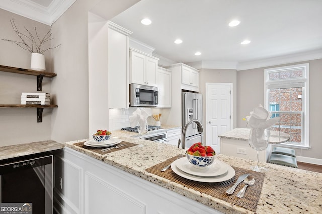 kitchen with light stone countertops, stainless steel appliances, white cabinetry, decorative backsplash, and crown molding