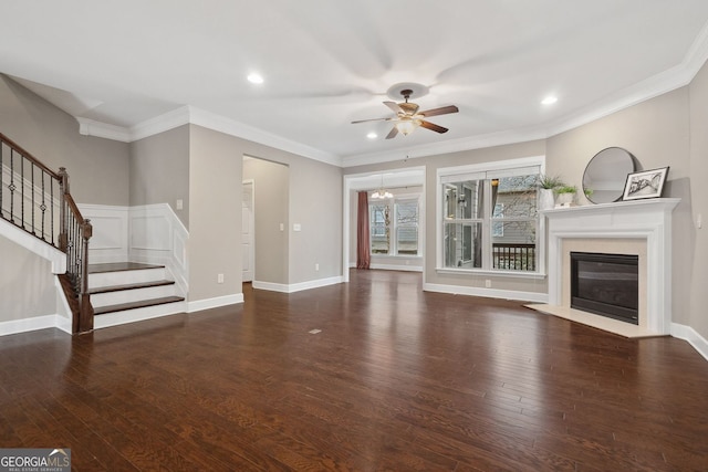 unfurnished living room with stairs, wood finished floors, ceiling fan with notable chandelier, and a fireplace with flush hearth