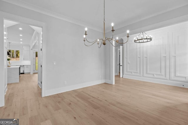 unfurnished dining area with light wood-style floors, recessed lighting, ornamental molding, and baseboards