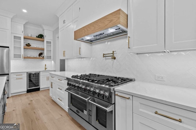 kitchen featuring wine cooler, stainless steel appliances, white cabinetry, custom exhaust hood, and crown molding