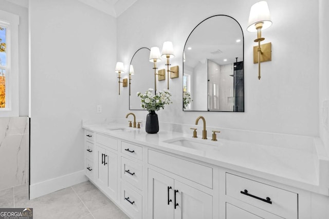 bathroom with a walk in shower, a sink, baseboards, and double vanity