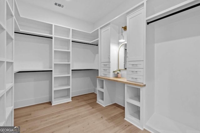 walk in closet featuring light wood-type flooring and visible vents