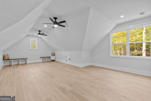 additional living space featuring baseboards, vaulted ceiling, visible vents, and light wood finished floors