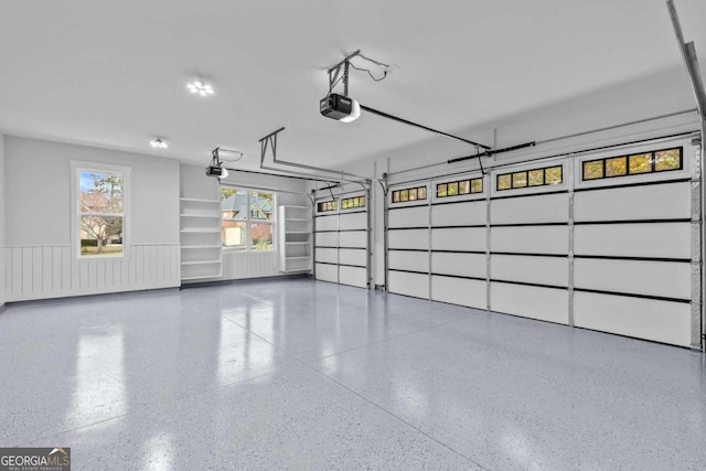 garage with a garage door opener and wainscoting