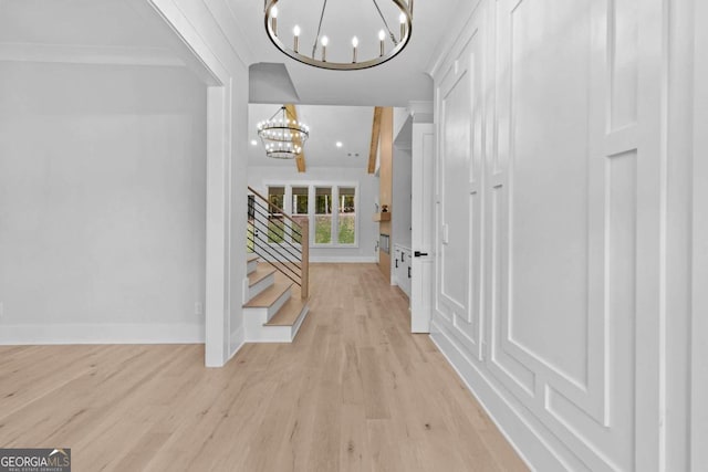 interior space featuring baseboards, light wood-style flooring, and a notable chandelier