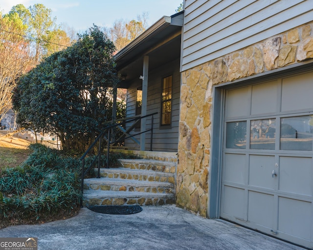 view of exterior entry featuring stone siding and covered porch