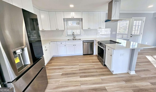 730 Keys Ferry Rd, Jackson, GA 30233 - kitchen with appliances with stainless steel finishes, island range hood, a peninsula, ornamental molding, and white cabinetry