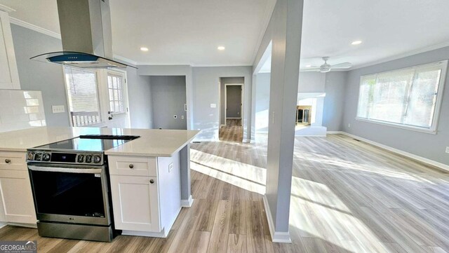 730 Keys Ferry Rd, Jackson, GA 30233 - kitchen with stainless steel range with electric cooktop, island exhaust hood, crown molding, ceiling fan, and open floor plan