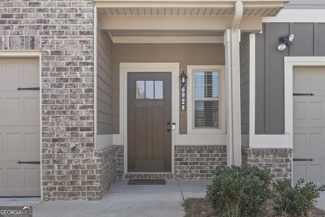 property entrance featuring a garage, brick siding, and a porch