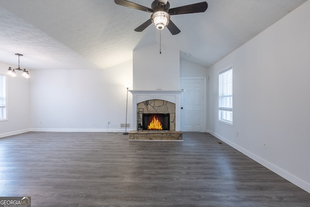 unfurnished living room with dark wood-style floors, a fireplace, lofted ceiling, a textured ceiling, and baseboards