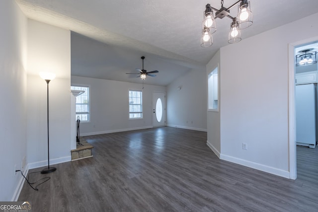 unfurnished living room with baseboards, dark wood-type flooring, vaulted ceiling, a textured ceiling, and ceiling fan with notable chandelier