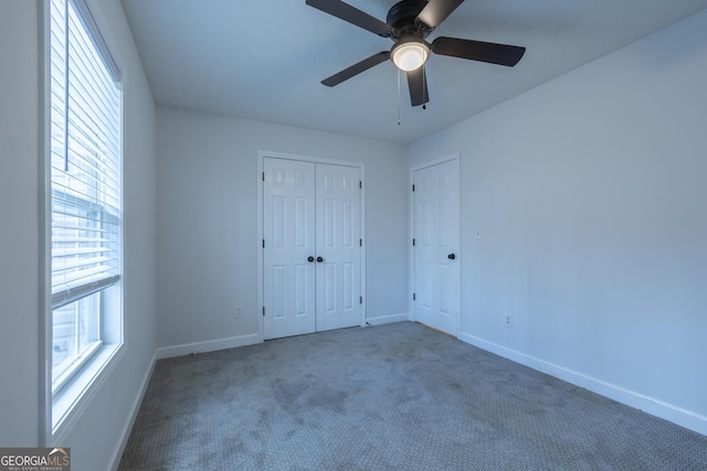 unfurnished bedroom featuring carpet floors, a closet, a ceiling fan, and baseboards