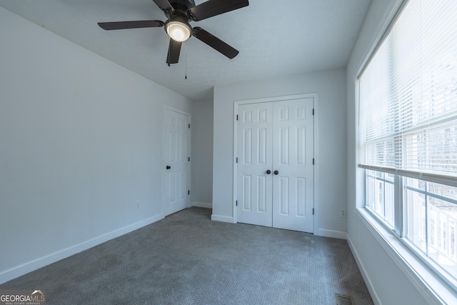 unfurnished bedroom featuring visible vents, baseboards, a ceiling fan, carpet flooring, and a closet