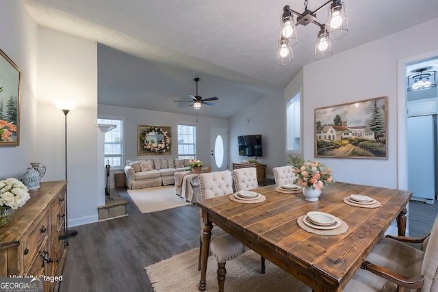 dining area with dark wood-type flooring, lofted ceiling, and ceiling fan with notable chandelier