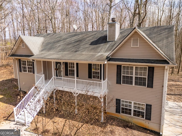 view of front of house featuring stairs, a chimney, and a porch