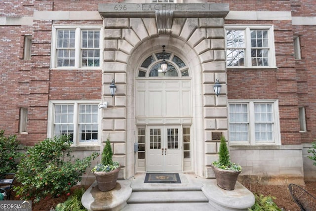 doorway to property featuring stone siding and brick siding