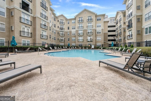 pool featuring fence and a patio