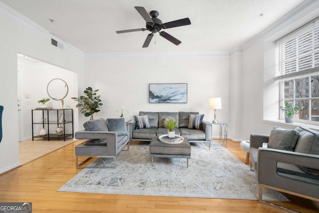 living room with visible vents, crown molding, a textured ceiling, and wood finished floors