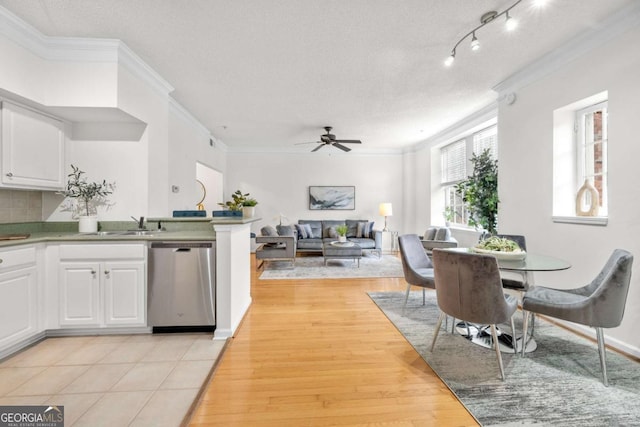 kitchen featuring ceiling fan, white cabinets, dishwasher, light wood finished floors, and crown molding