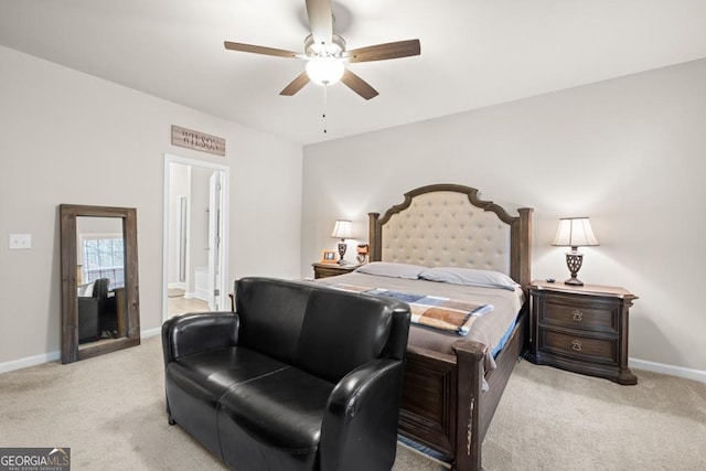 bedroom featuring light carpet, ceiling fan, baseboards, and ensuite bathroom