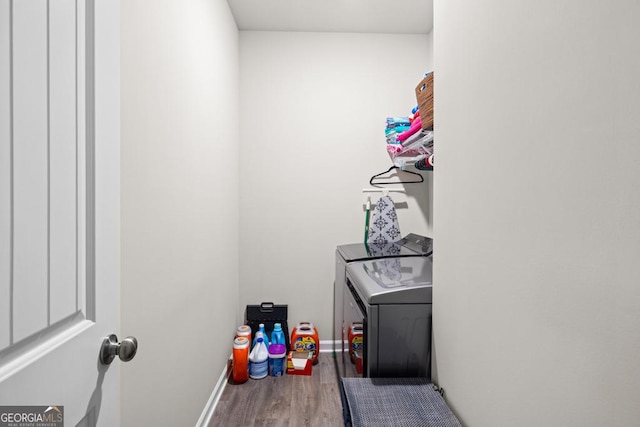 washroom with laundry area, baseboards, separate washer and dryer, and wood finished floors