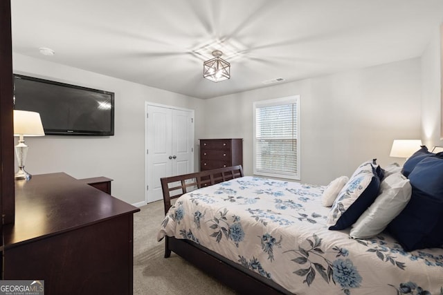 carpeted bedroom with a closet, visible vents, and baseboards