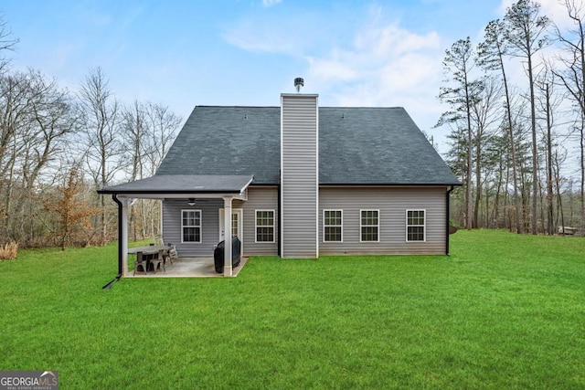 back of house featuring a patio, a yard, and a chimney