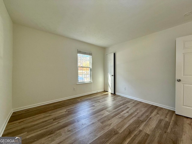 spare room featuring wood finished floors and baseboards