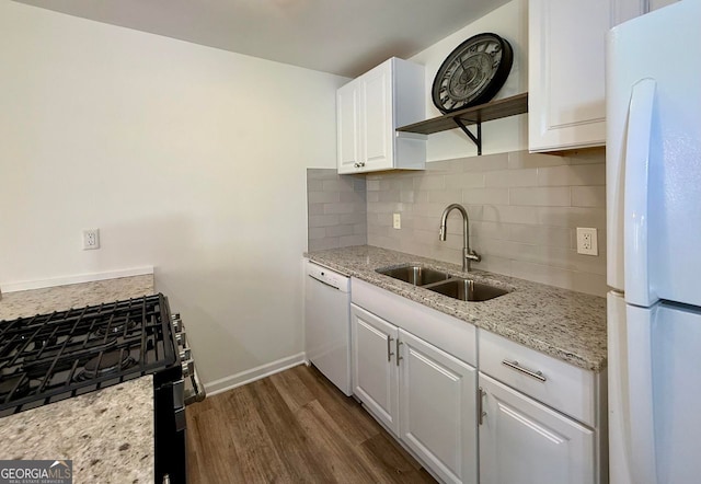 kitchen featuring white appliances, tasteful backsplash, white cabinets, dark wood finished floors, and a sink