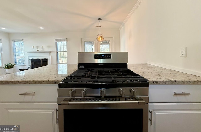 kitchen with ornamental molding, light stone countertops, a fireplace, white cabinetry, and gas stove