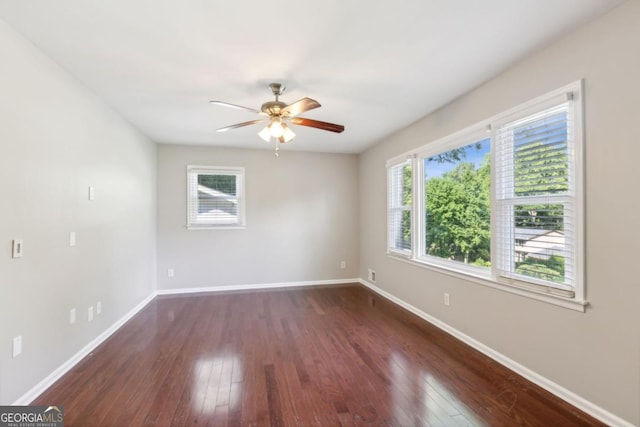 spare room featuring ceiling fan, baseboards, and dark wood finished floors