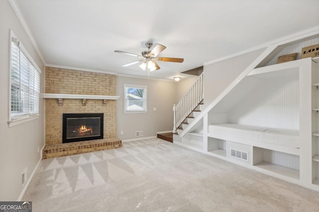 unfurnished living room with visible vents, ornamental molding, stairs, carpet floors, and built in shelves