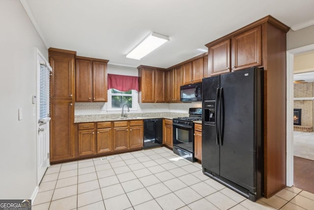 kitchen with light tile patterned floors, ornamental molding, brown cabinets, black appliances, and a sink