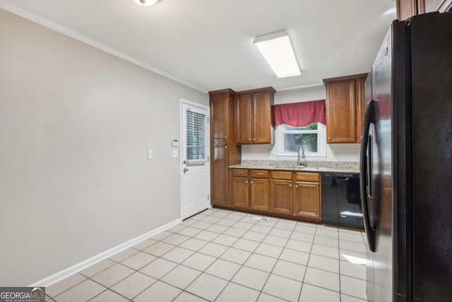 kitchen with light tile patterned floors, baseboards, brown cabinets, decorative backsplash, and black appliances