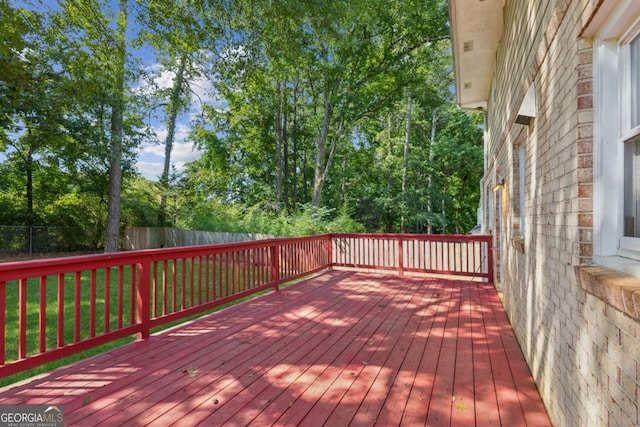 wooden deck featuring a lawn and fence