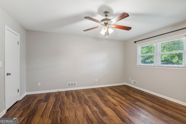 unfurnished room featuring baseboards, visible vents, and dark wood-style flooring