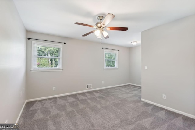 unfurnished room featuring ceiling fan, carpet flooring, visible vents, and baseboards