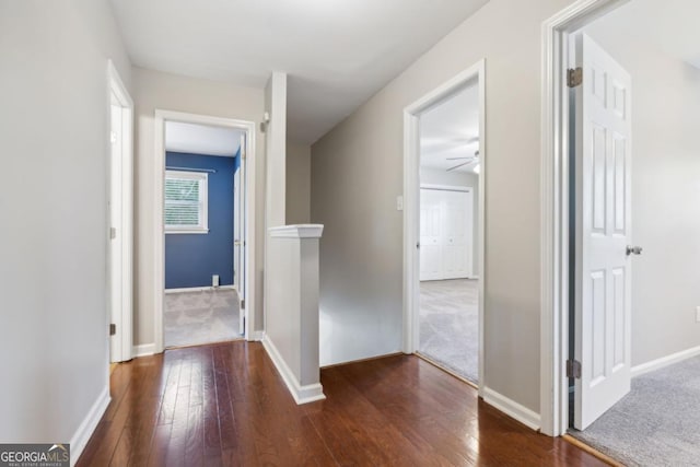 corridor with hardwood / wood-style flooring and baseboards