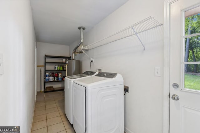 laundry area featuring laundry area, light tile patterned floors, water heater, and washer and clothes dryer