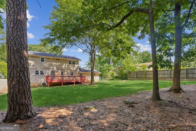 view of yard featuring a wooden deck and fence