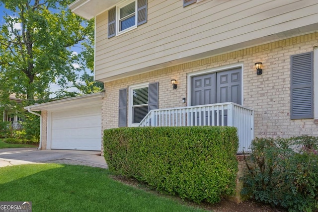 doorway to property featuring driveway and brick siding