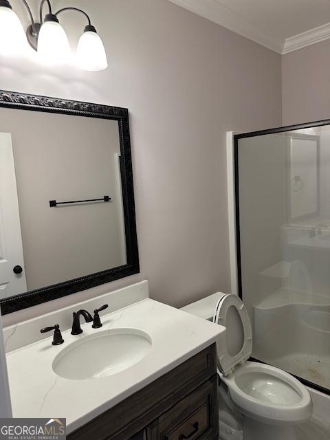 full bathroom featuring toilet, a stall shower, crown molding, and vanity