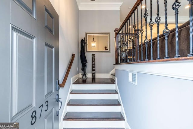 stairs featuring ornamental molding and baseboards