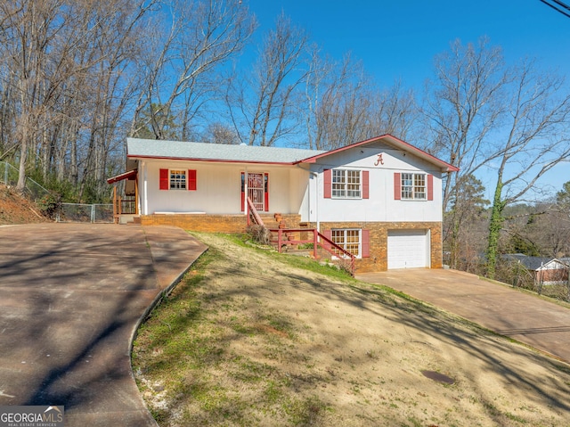 view of front of property with concrete driveway, brick siding, and an attached garage