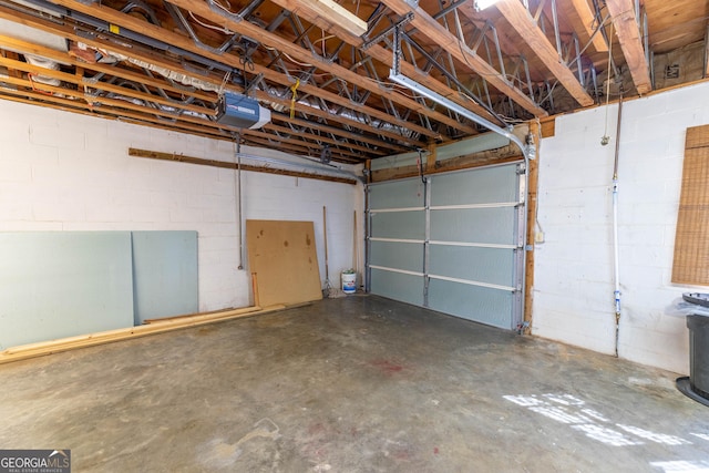 garage featuring concrete block wall and a garage door opener