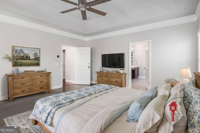 bedroom with a raised ceiling, ornamental molding, ensuite bath, wood finished floors, and baseboards